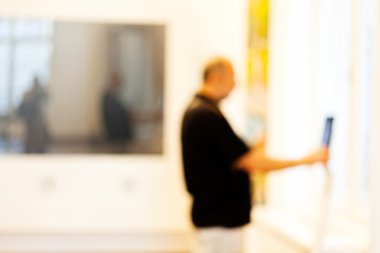 Older man tries tablet showpiece at technology expo; blurred 100%