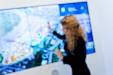 Woman is representing showpiece at technology expo; blurred 100%