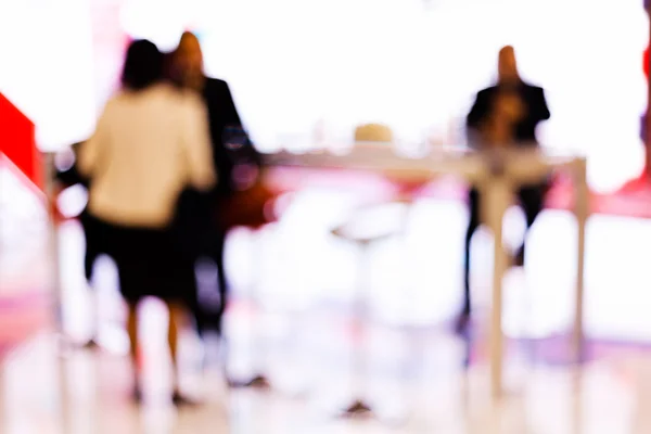 Blur of people sitting at bar table at coffee shop; blurred 100%