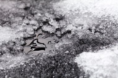 Asfaltta eriyen küçük kar birikintisi