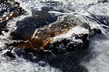 Küçük kayalıklarda buzla kaplı donmuş zemin kış sabahı