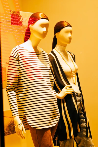 mannequins in a store window on the yellow background, note shallow depth of field
