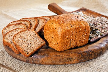 rye bread with seeds on a wooden plate clipart