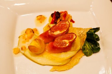 Beyaz tabakta gözleme, jambon ve sebzeli aperatif.