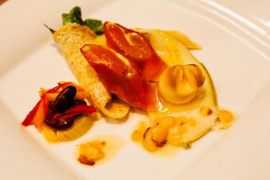 Beyaz tabakta gözleme, jambon ve sebzeli aperatif.