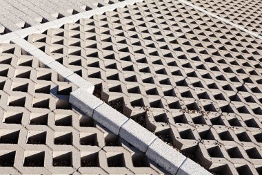 Çevresinde kaldırım olan boş beton levhaların park yeri.