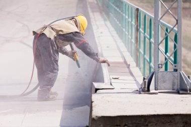 blasting of concrete, note shallow depth of field clipart
