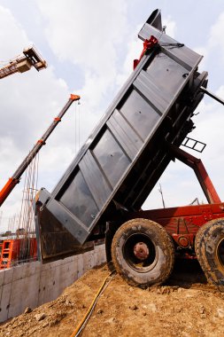 bir inşaat sahasında bir kamyondan boşaltma malzemeleri