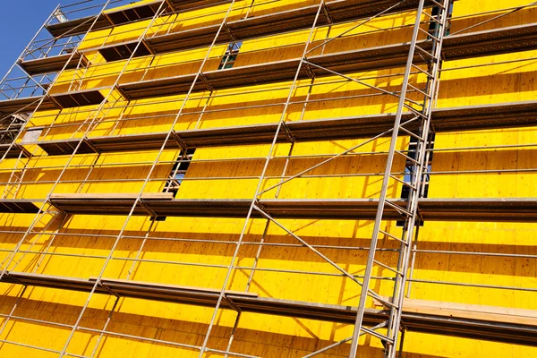 建筑物上的黄色防护防水油布和脚手架 — 图库照片