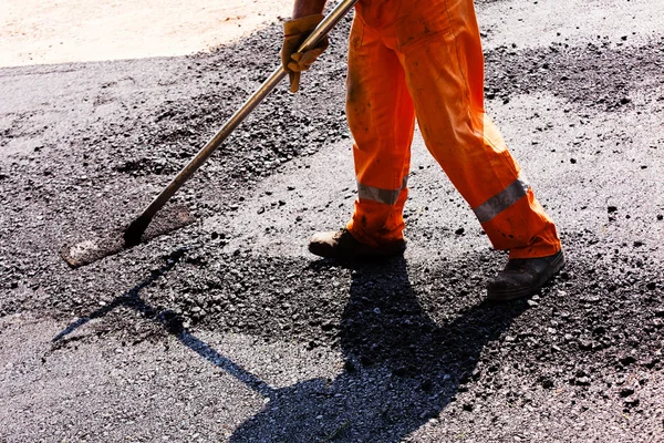 Worker on asphalting the road