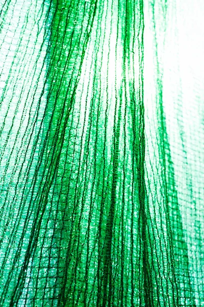 thick green plastic safety net for construction site, note shallow depth of field