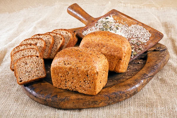 bread and slices of bread with seeds on the wooden board, note shallow depth of field