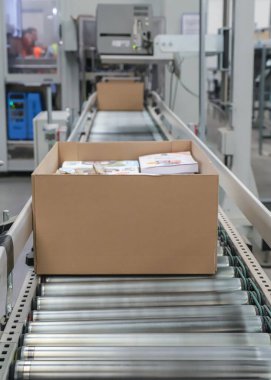 Bir lojistik deposunda ambalaj hattı. Modern bir taşıma bandı