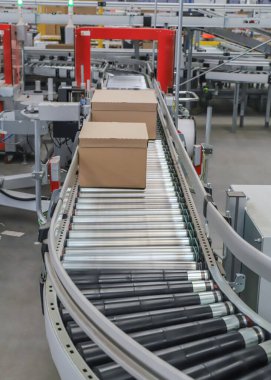 Bir lojistik deposunda ambalaj hattı. Modern bir taşıma bandı