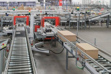 Bir lojistik deposunda ambalaj hattı. Modern bir taşıma bandı