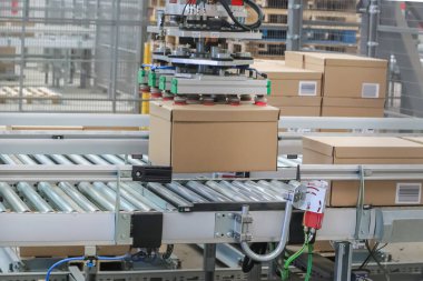 Bir lojistik deposunda ambalaj hattı. Modern bir taşıma bandı