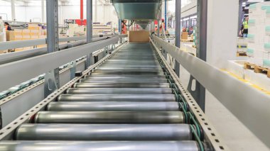 Bir lojistik deposunda ambalaj hattı. Modern bir taşıma bandı