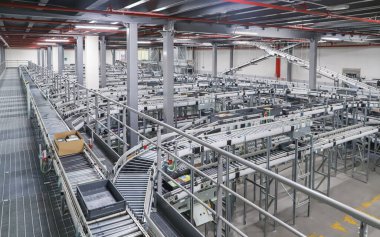 Bir lojistik deposunda ambalaj hattı. Modern bir taşıma bandı