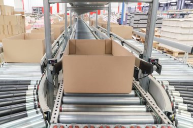 Bir lojistik deposunda ambalaj hattı. Modern bir taşıma bandı