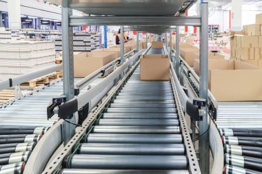 Bir lojistik deposunda ambalaj hattı. Modern bir taşıma bandı