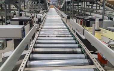 Bir lojistik deposunda ambalaj hattı. Modern bir taşıma bandı