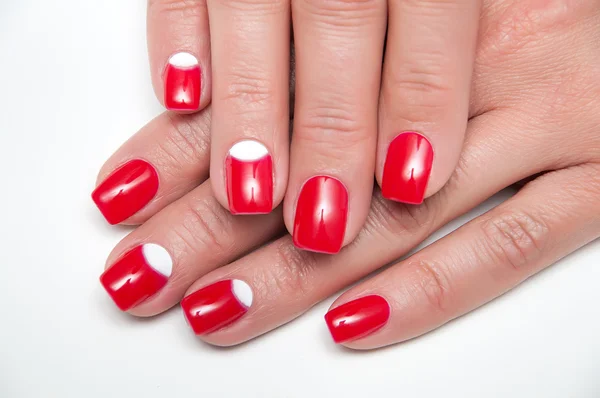 Manicure rossa con inserti bianchi su mani abbronzate — Foto Stock