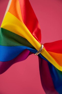 Pembe arka planda alyansla tutulan gökkuşağı bayrağı