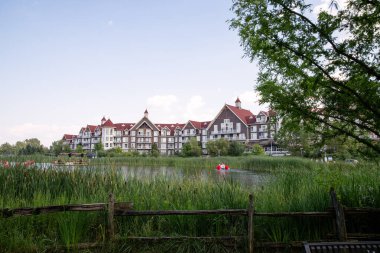 Mavi Dağlar 'da ahşap çitleri ve yeşil ağaçları olan bir göl manzarası..