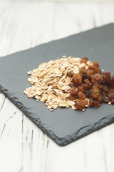 Harina de avena y pasas en la pizarra — Foto de Stock