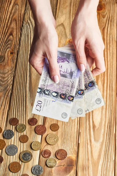 Vrouwelijke hand aanhouden van een Britse geld. — Stockfoto