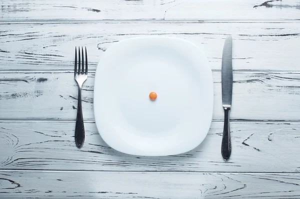 Апельсиновая таблетка или конфеты на большой пустой тарелке . — стоковое фото