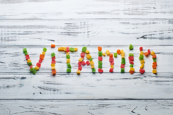 Слово "витамин" написано кусочки конфет
.