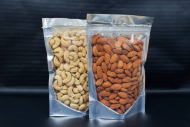Bademler - Badam ve Cashew fındıkları - Kesu Nuttz siyah arkaplan üzerine şeffaf paket