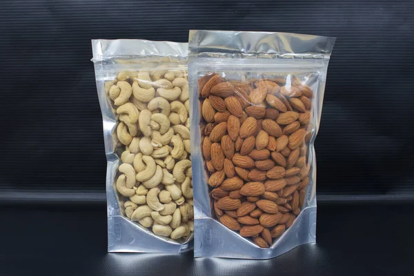 Bademler - Badam ve Cashew fındıkları - Kesu Nuttz siyah arkaplan üzerine şeffaf paket