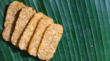 Altın kızartılmış tempeh muz yaprağında sunuldu çıtır çıtır dokular ve geleneksel Endonezya gıda konsepti ile bitki bazlı protein ve otantik Asya mutfağı