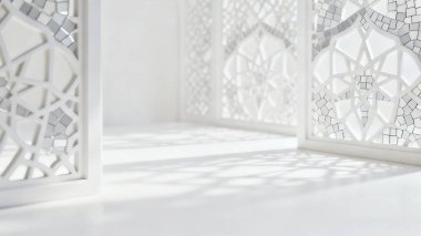 Zarif İslami geometrik gölgeler ve parlak beyaz bir yüzey üzerinde camiden esinlenerek sakin, lüks ve minimalist bir atmosfer yaratan yumuşak odaklı arka plan Ramazan, Kurban Bayramı ve İslam tasarım projeleri için idealdir..