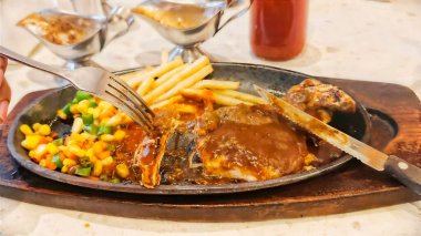 Kızarmış patates kızartması ve renkli taze sebzelerle servis edilen sulu ızgara tavuk bifteği restoran menüsü, yemek reklamı ve ticari mutfak içeriği için mükemmel.