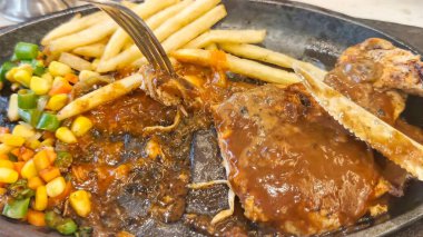 Kızarmış patates kızartması ve renkli taze sebzelerle servis edilen sulu ızgara tavuk bifteği restoran menüsü, yemek reklamı ve ticari mutfak içeriği için mükemmel.