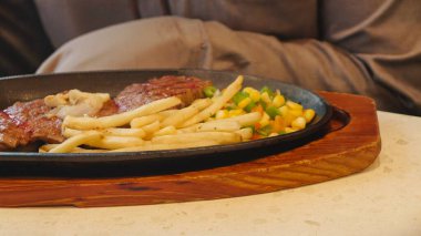 Kızarmış patates kızartması ve renkli taze sebzelerle servis edilen sulu ızgara tavuk bifteği restoran menüsü, yemek reklamı ve ticari mutfak içeriği için mükemmel.