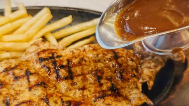 Kızarmış patates kızartması ve renkli taze sebzelerle servis edilen sulu ızgara tavuk bifteği restoran menüsü, yemek reklamı ve ticari mutfak içeriği için mükemmel.