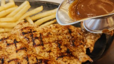 Kızarmış patates kızartması ve renkli taze sebzelerle servis edilen sulu ızgara tavuk bifteği restoran menüsü, yemek reklamı ve ticari mutfak içeriği için mükemmel.