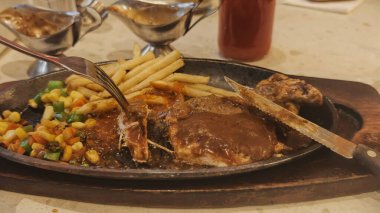 Kızarmış patates kızartması ve renkli taze sebzelerle servis edilen sulu ızgara tavuk bifteği restoran menüsü, yemek reklamı ve ticari mutfak içeriği için mükemmel.