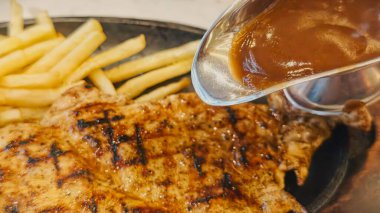 Kızarmış patates kızartması ve renkli taze sebzelerle servis edilen sulu ızgara tavuk bifteği restoran menüsü, yemek reklamı ve ticari mutfak içeriği için mükemmel.