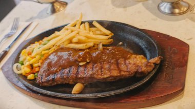 Kızarmış patates kızartması ve renkli taze sebzelerle servis edilen sulu ızgara tavuk bifteği restoran menüsü, yemek reklamı ve ticari mutfak içeriği için mükemmel.