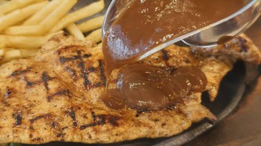 Kızarmış patates kızartması ve renkli taze sebzelerle servis edilen sulu ızgara tavuk bifteği restoran menüsü, yemek reklamı ve ticari mutfak içeriği için mükemmel.