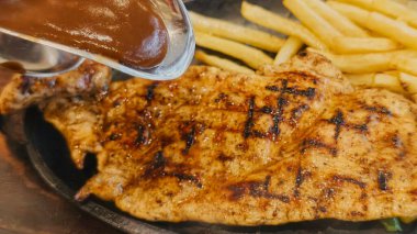 Kızarmış patates kızartması ve renkli taze sebzelerle servis edilen sulu ızgara tavuk bifteği restoran menüsü, yemek reklamı ve ticari mutfak içeriği için mükemmel.