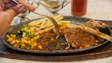 Kızarmış patates kızartması ve renkli taze sebzelerle servis edilen sulu ızgara tavuk bifteği restoran menüsü, yemek reklamı ve ticari mutfak içeriği için mükemmel.