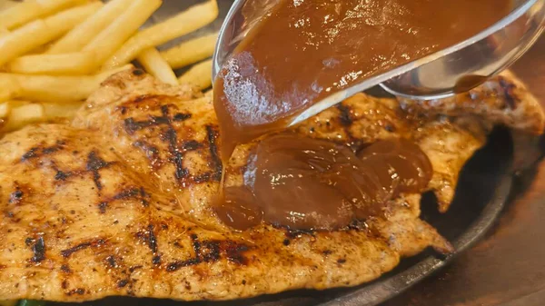 Kızarmış patates kızartması ve renkli taze sebzelerle servis edilen sulu ızgara tavuk bifteği restoran menüsü, yemek reklamı ve ticari mutfak içeriği için mükemmel.