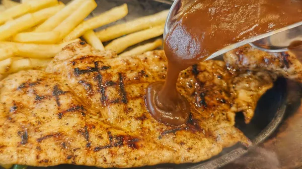 Kızarmış patates kızartması ve renkli taze sebzelerle servis edilen sulu ızgara tavuk bifteği restoran menüsü, yemek reklamı ve ticari mutfak içeriği için mükemmel.