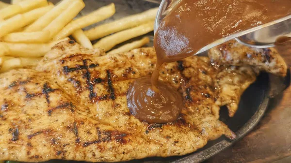 Kızarmış patates kızartması ve renkli taze sebzelerle servis edilen sulu ızgara tavuk bifteği restoran menüsü, yemek reklamı ve ticari mutfak içeriği için mükemmel.